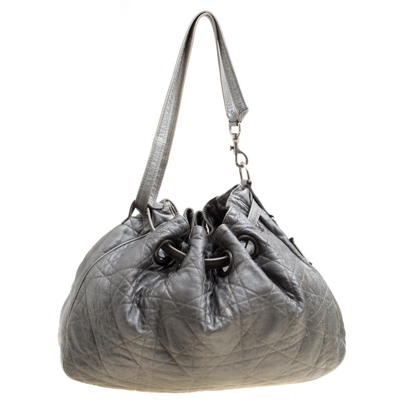 This stylish hobo from Dior has been crafted from grey leather and styled with their signature cannage pattern. The bag features a shoulder strap, a D cutout charm and a drawstring closure. The insides are fabric lined and spacious enough to hold