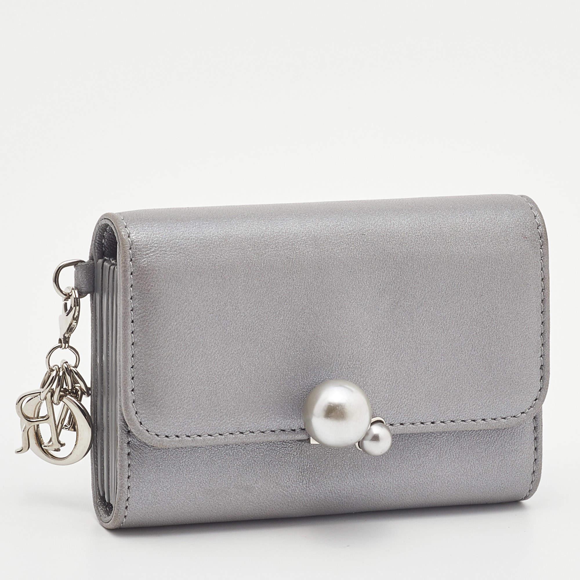 This stylish and functional card case from Dior makes for a great accessory. Crafted from quality leather in Italy, it carries a grey hue and silver-tone hardware . It has multiple card slots and classic Dior letter charms.


Includes
Original