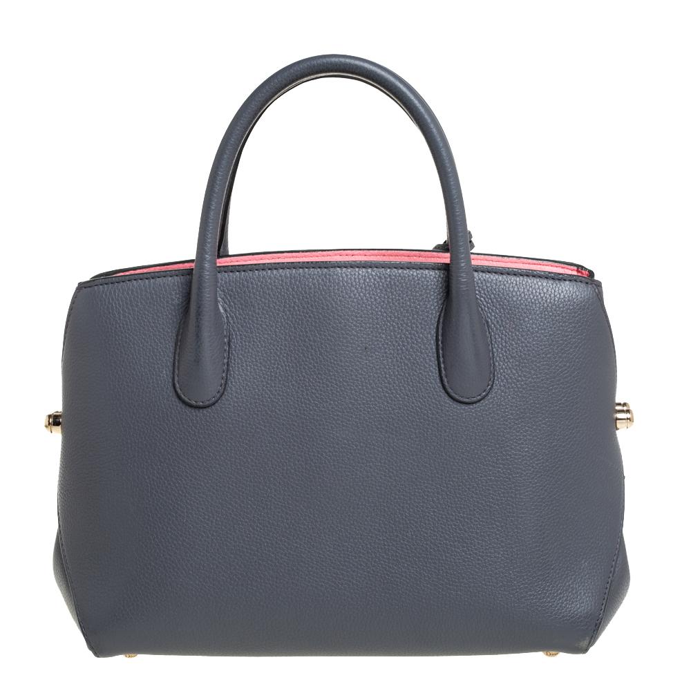 This Open Bar tote from Dior is designed to assist you with style and practical ease! It comes crafted from leather and features dual top handles. It carries the 'DIOR' letter charms within a clochette and its top opens to a leather interior that
