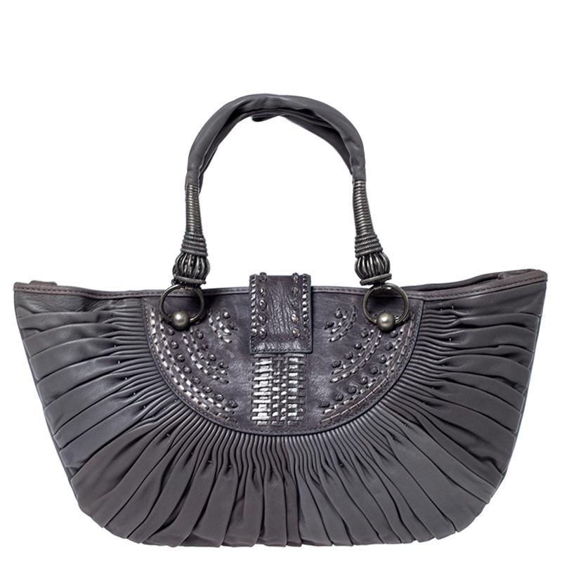 Expertly crafted from grey leather into a unique silhouette, this Plisse tote from the house of Dior exhibits an exquisite design. It has a spacious interior lined with the finest nylon and equipped with a zipped pocket. With an impressive pleated