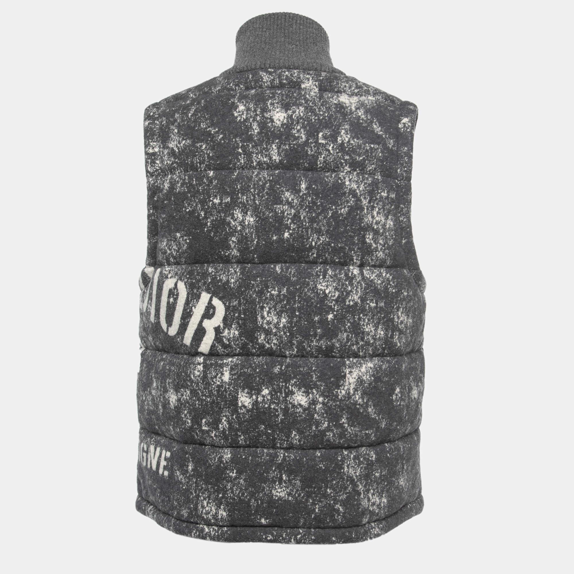 The Dior vest is a stylish and cozy outerwear piece. Crafted from high-quality cotton fleece material, it features a sleek grey color and Dior's signature print. This sleeveless vest offers warmth and fashion-forward design, making it a versatile