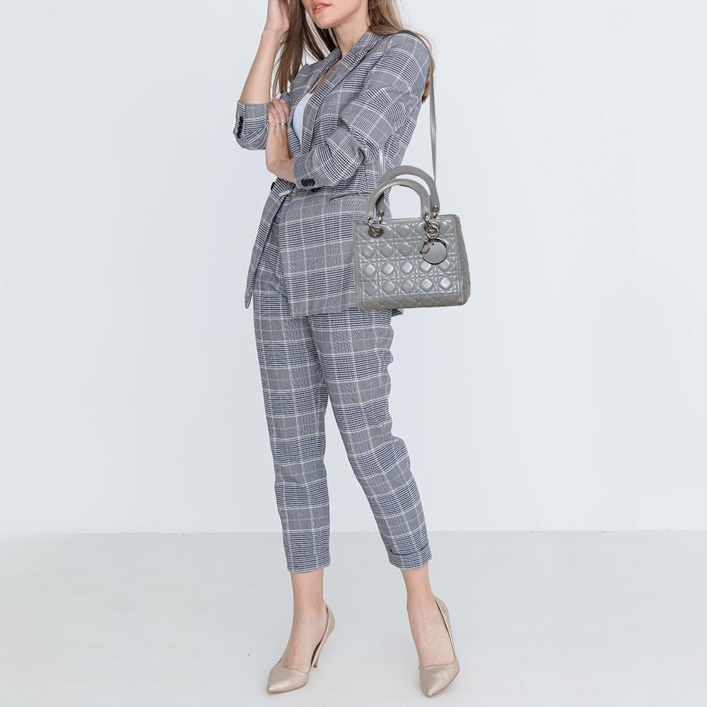 A timeless status and great design mark the Lady Dior tote. It is an iconic bag that women continue to invest in to this day. This grey Lady Dior tote has been crafted using leather and carries the signature Cannage quilt. It is equipped with a