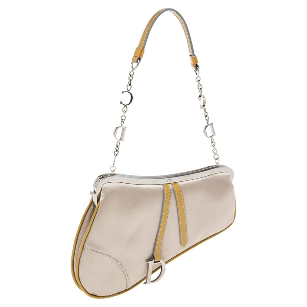 Owing to its uniquely-crafted silhouette and timeless elegance, the Saddle bag from Dior remains one of the most sought-after designs of the brand. It is carved using grey satin and patent leather, with a D charm on the front. The Saddle is complete