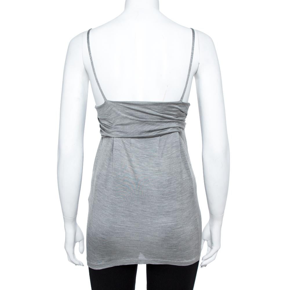 This sleeveless top by Dior exudes sophistication and femininity. Crafted from 100% silk, this luxurious top comes in a lovely shade of grey. It features a floral applique on the top that lends interest, two thin straps, and a fitted silhouette. It