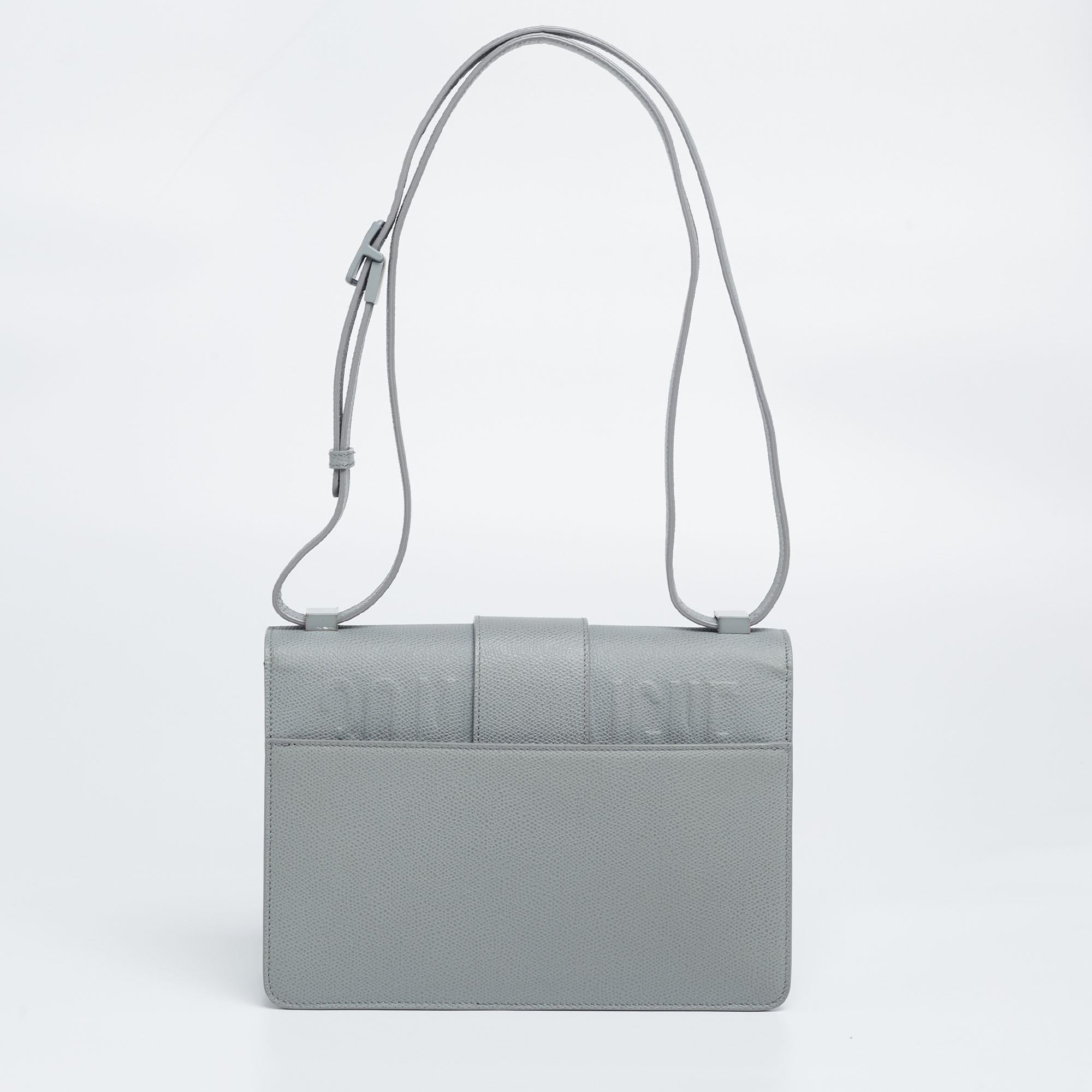 A fine collaboration of historical inspiration, artisanal savoir-faire, and signature brand aesthetic, this 30 Montaigne bag from Dior is a creation brimming with excellence and allure. This version displays a grey ultramatte leather exterior with a