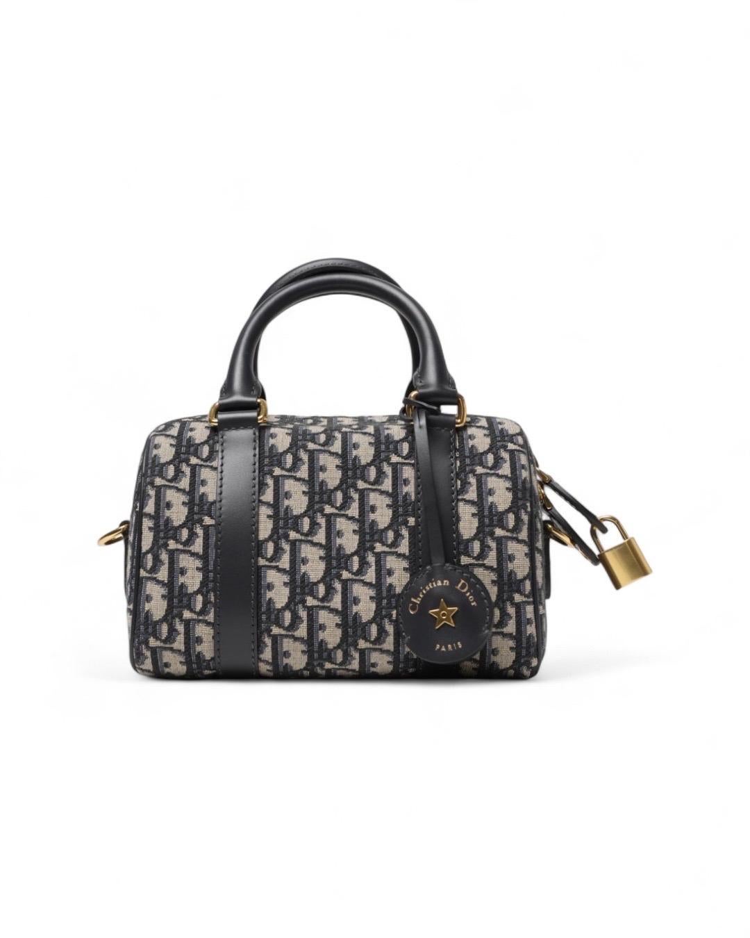 Borsa firmata Dior, modello Groove nella misura small, realizzata in tela nella classica fantasia Jacquard obliqua con inserti in pelle blu e hardware dorato. Dotata di una chiusura semicircolare a zip, internamente rivestita in tela beige con due