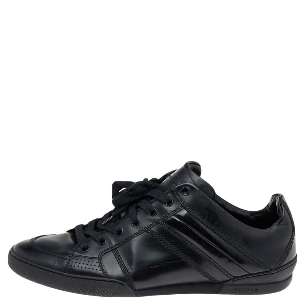 These sneakers from the House of Dior Homme have been crafted from quality materials and feature a sturdy silhouette. Made from black leather and patent leather on the exterior, they show covered toes and lace-up fastenings on the vamps. These