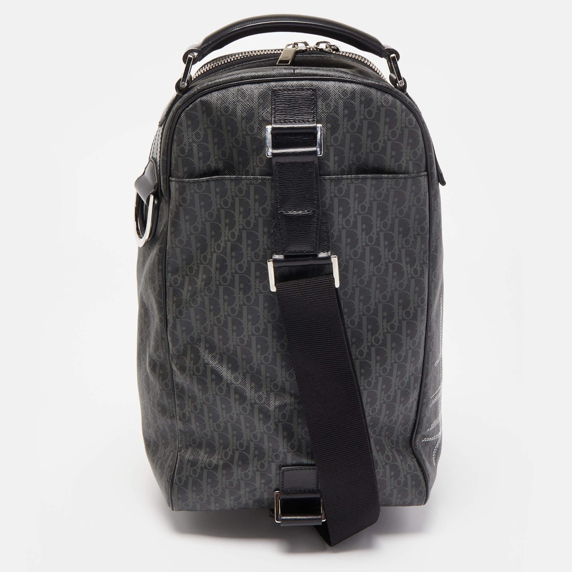 The Dior Homme bag is a stylish accessory. Its dark grey color and distinctive stitched print add a touch of sophistication. Made from coated canvas, it features a sling design, making it versatile and easy to carry. Perfect for the fashion-forward