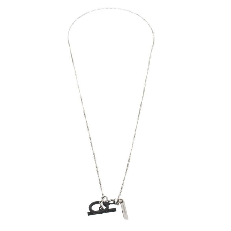 This chain from Dior Homme definitely needs to be on your wishlist! It is crafted from silver-tone metal and features a black coated toggle that acts as a centre piece. An attached brand name engraved accent and an interlocking chain complete this