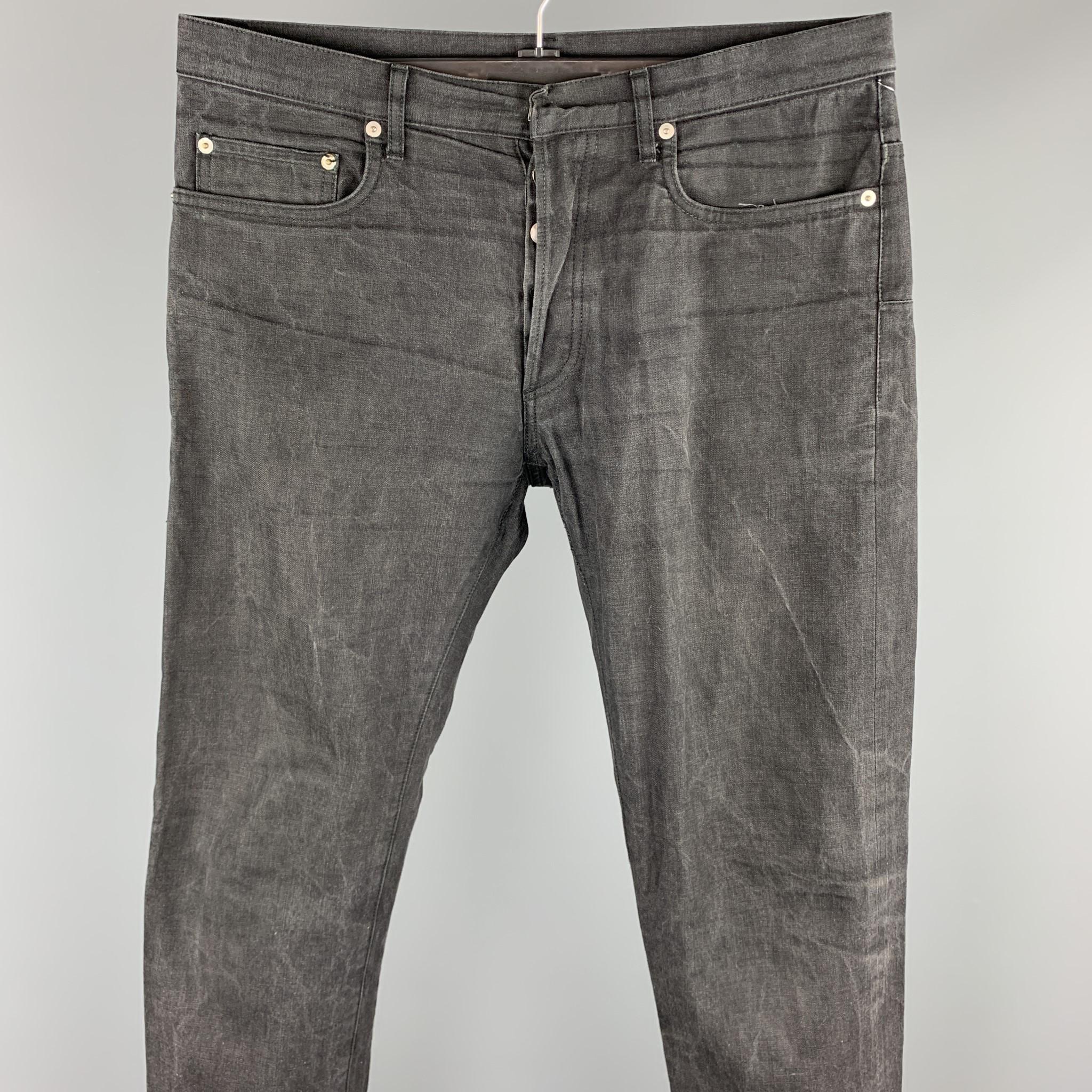 DIOR HOMME jeans comes in a black washed denim featuring a regular fit and a button fly closure. Made in Japan.

Very Good Pre-Owned Condition.
Marked: 32

Measurements:

Waist: 34 in.
Rise: 9 in. 
Inseam: 31 in. 
