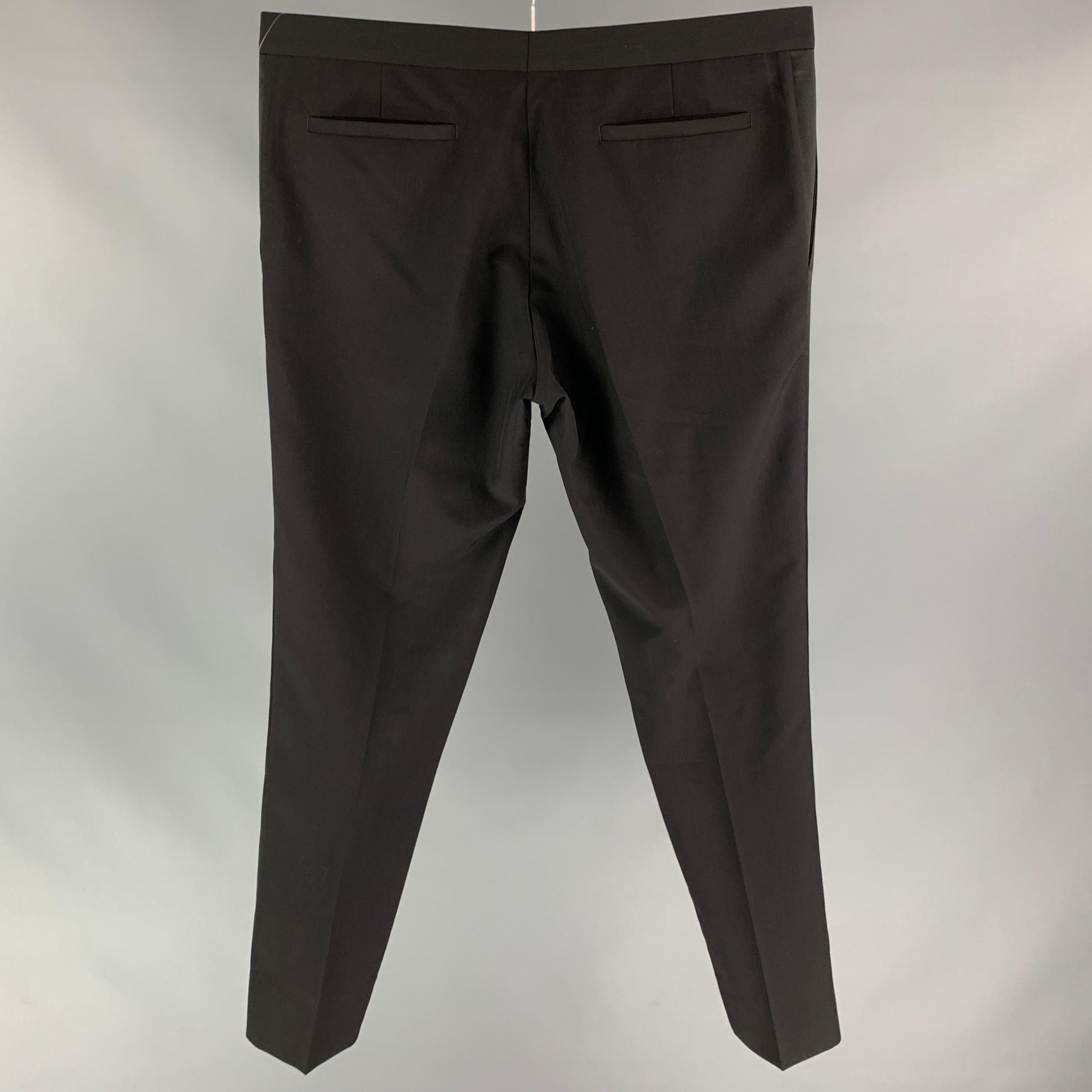 DIOR HOMME tuxedo dress pants comes in a black wool / mohair featuring a flat front, front tab, and a zip fly closure. Made in Italy.

Very Good Pre-Owned Condition.
Marked: 52

Measurements:

Waist: 36 in.
Rise: 10 in.
Inseam: 31 in. 

SKU: