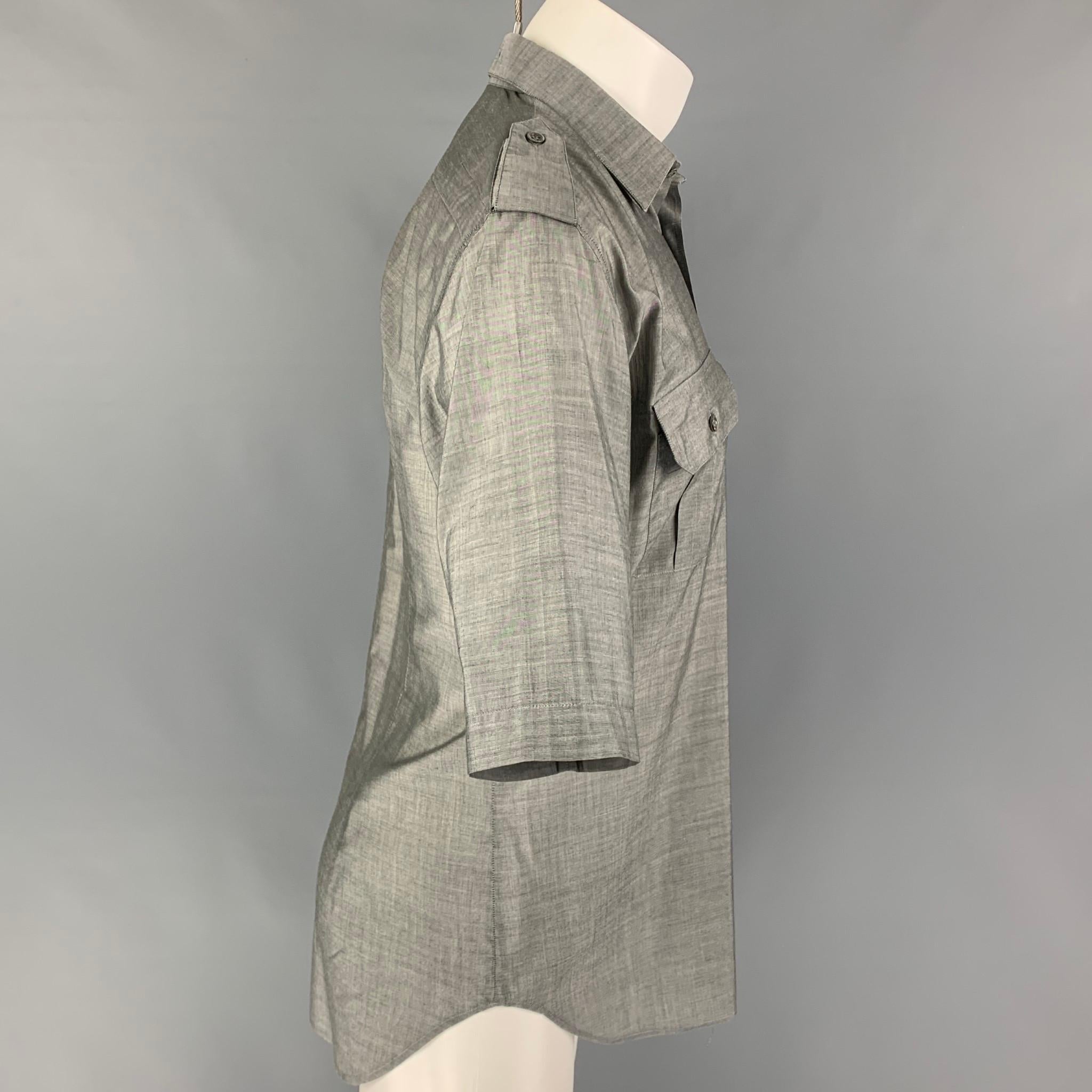 DIOR HOMME short sleeve shirt comes in a gray cotton / polyurethane featuring a spread collar, epaulettes, patch pockets, and a button up closure. 

Very Good Pre-Owned Condition.
Marked: 41

Measurements:

Shoulder: 19 in.
Chest: 41 in.
Sleeve: 13