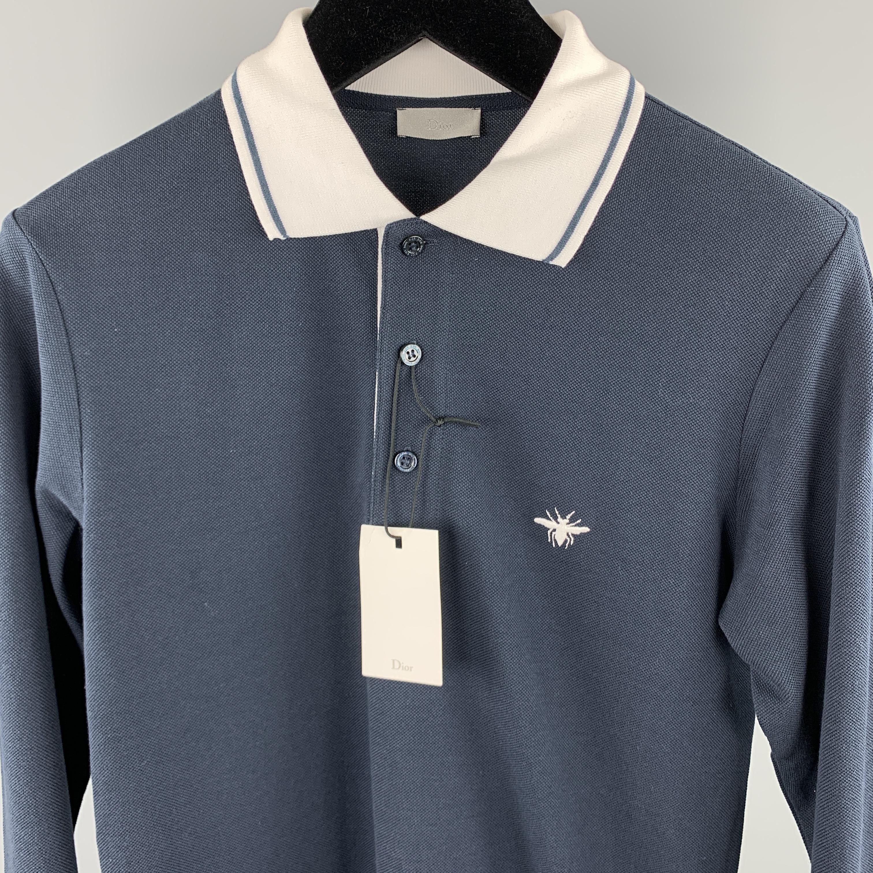 DIOR HOMME long sleeve POLO comes in a solid navy pique material, featuring a contrast white collar, an embroidery at chest, a half buttoned front, and a contrast white trim at cuffs. 

New with Tags.
Marked: IT 44

Measurements:

Shoulder: 16 in.