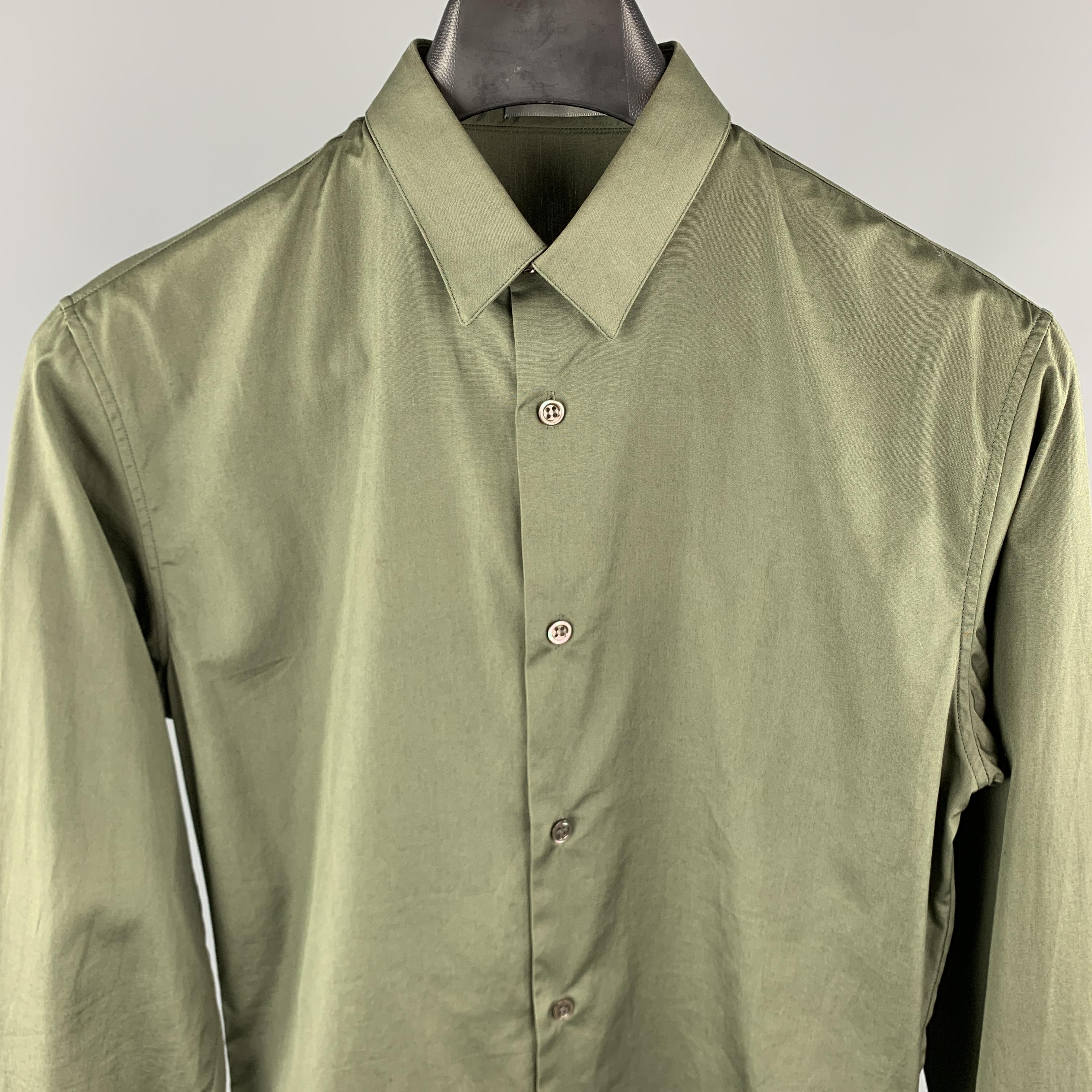 DIOR HOMME Long Sleeve Shirt comes in an olive tone in a solid cotton material, with a narrow collar, darts at back, buttoned cuffs, button up. Made in Italy.

Excellent Pre-Owned Condition.
Marked: 37

Measurements:

Shoulder: 16.5 in. 
Chest: 39