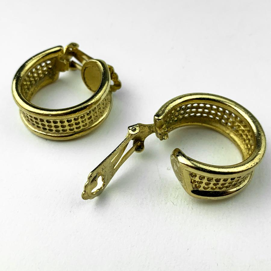 The clips are signed CHRISTIAN DIOR. They represent two hoop earrings in metal gilded with fine gold and a mesh pattern.
The ear clips are in good condition. Micro-scratches absolutely invisible to the naked eye. The creoles have a diameter of 2.5