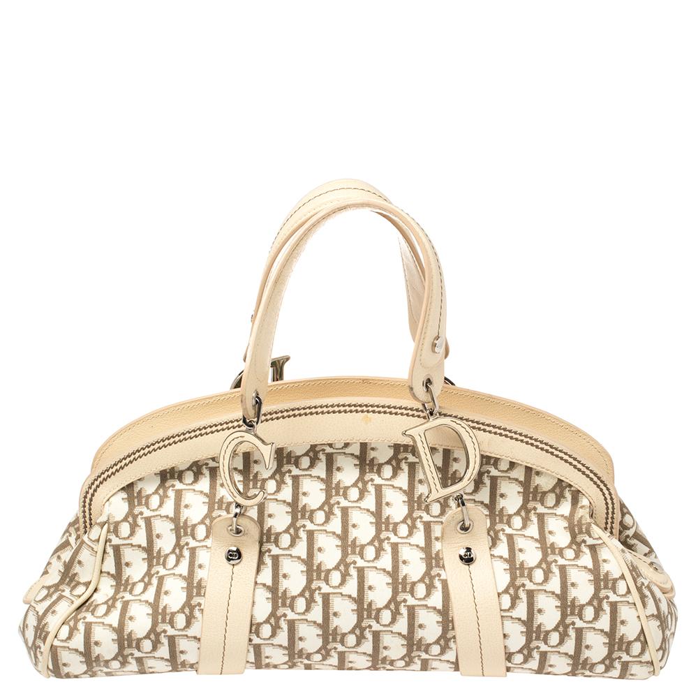 Head to your next social event carrying this chic Trotter bag from Dior. Designed in a Diorissimo-coated canvas body, this bag is finished with leather trims, silver-tone hardware, and floral embroidery on the front. It comes fitted with two top
