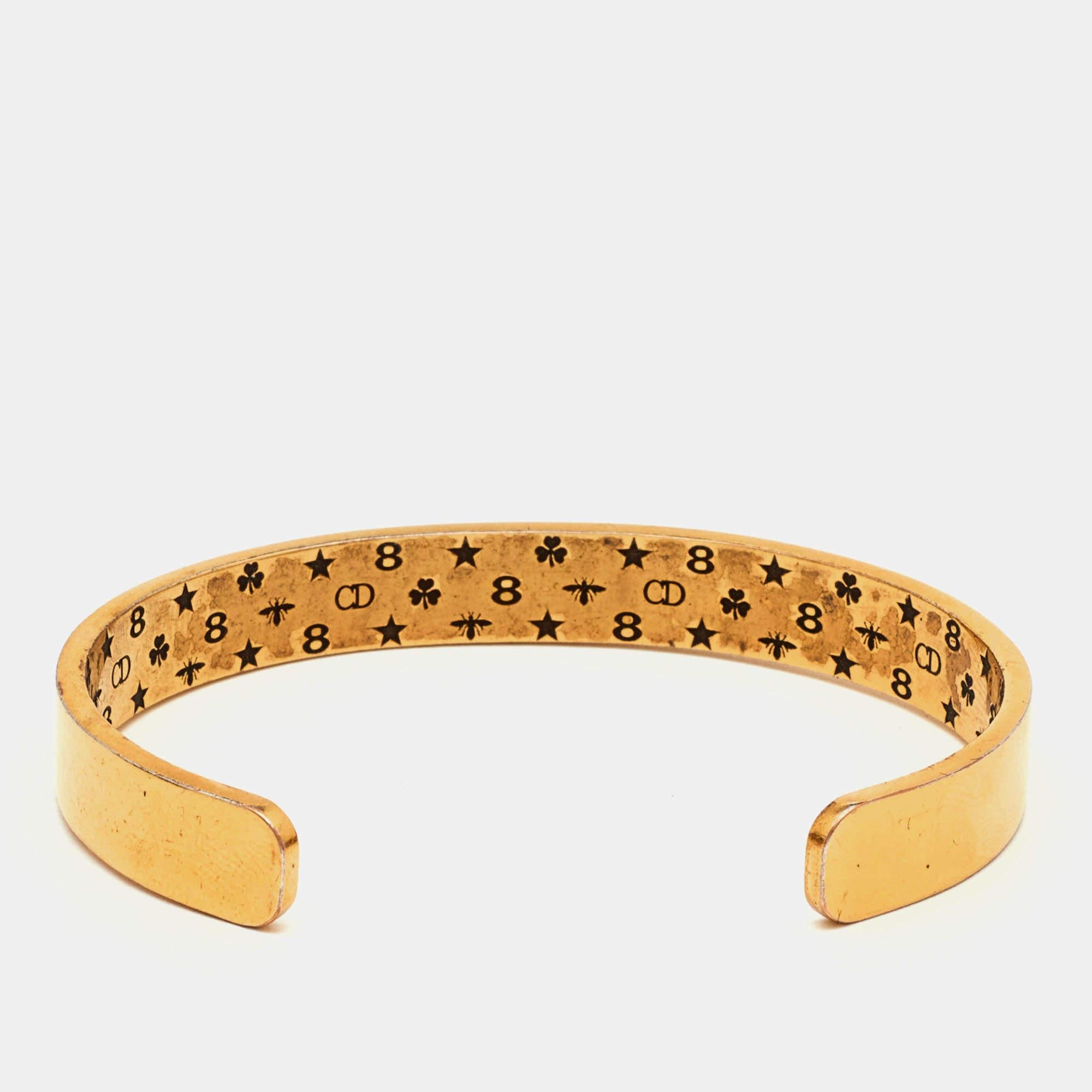 Esta pulsera Dior Jadior Revolution es tan sencilla, sin esfuerzo y, sin embargo, tan chic y lujosa que se lleva una y otra vez una vez comprada. Nunca pasa de moda. Fabricada en metal dorado, esta pulsera está embellecida con motivos de la firma.


