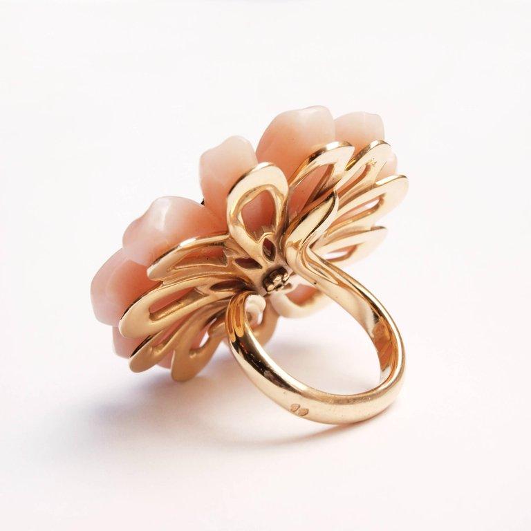 A Christian Dior pink opal and diamond ring designed by Victoire de Castellane. The brilliant-cut diamond stamen cluster centre to carved pink opal petals, the hoop forming the stem size L, in maker's box. A stunning piece of jewellery 