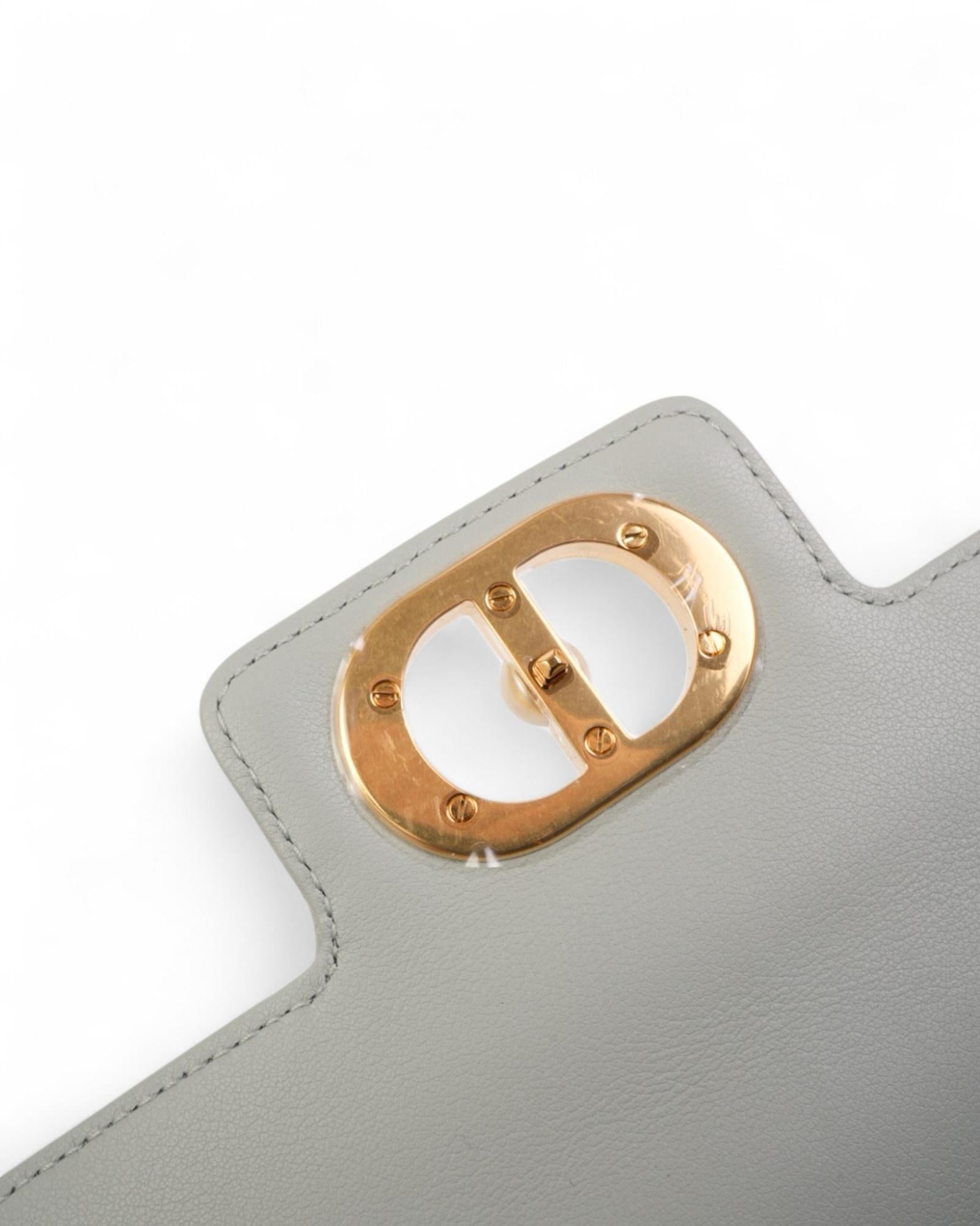 Dior's signature bag, model Jolie, made of fine calfskin in the refined shade of pistachio green, with gold hardware adding a touch of luxury. The bag features a double front flap with interlocking closure, embellished with the classic 