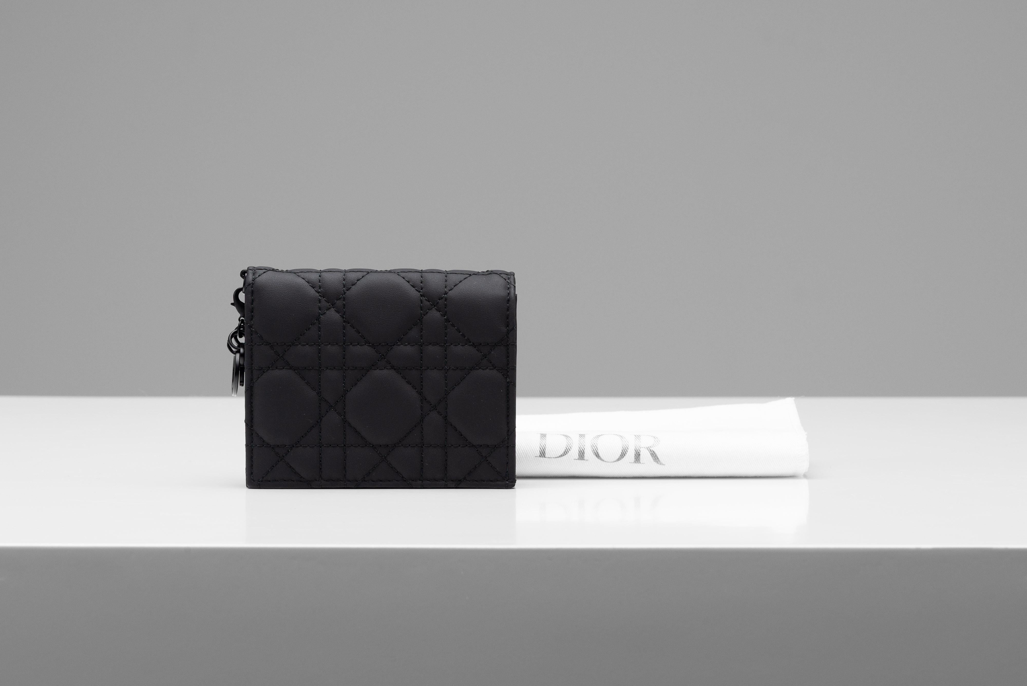 Aus der Kollektion von SAVINETI bieten wir dieses Portemonnaie von Lady Dior an:

- Marke: Dior 
- Modell: Lady Dior Mini Geldbörse
- Farbe: Ultramattes Schwarz
- Jahr: 2023
- Zustand: Neuer Zustand (es lag nur im Schrank)
- MATERIALIEN: