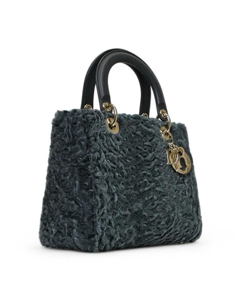 Sac Dior, modèle Lady en taille Medium, en tissu de fourrure gris avec garnitures en cuir et ferrures dorées. Doté d'une fermeture à rabat, l'intérieur est doublé en toile ton sur ton et dispose d'une poche pratique qui, malgré sa taille compacte,