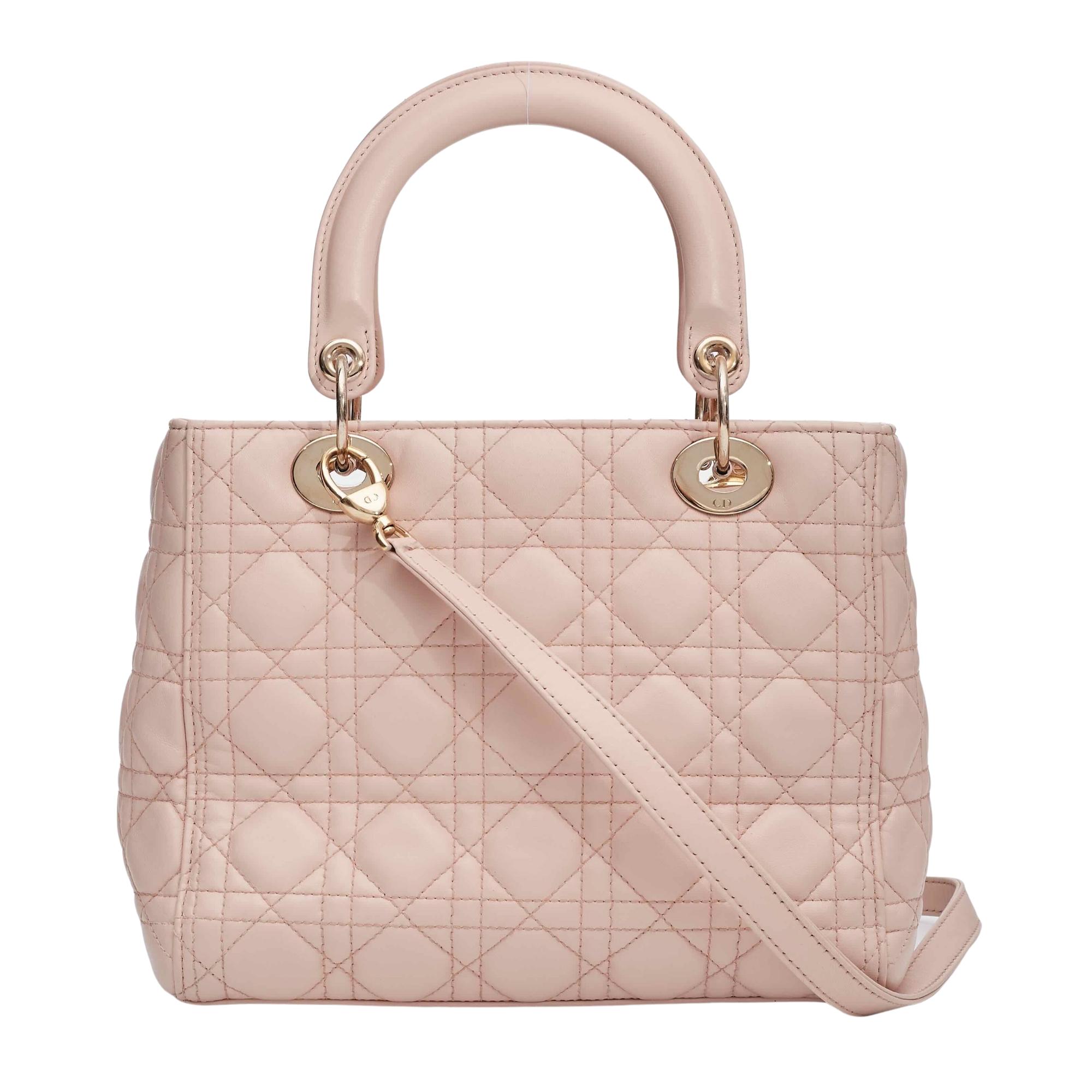 This bag is made of soft and supple cannage quilted lambskin leather in light pink. The bag features leather top handles and an optional adjustable shoulder strap with polished light gold hardware. The top zipper opens to a dark brown Dior monogram