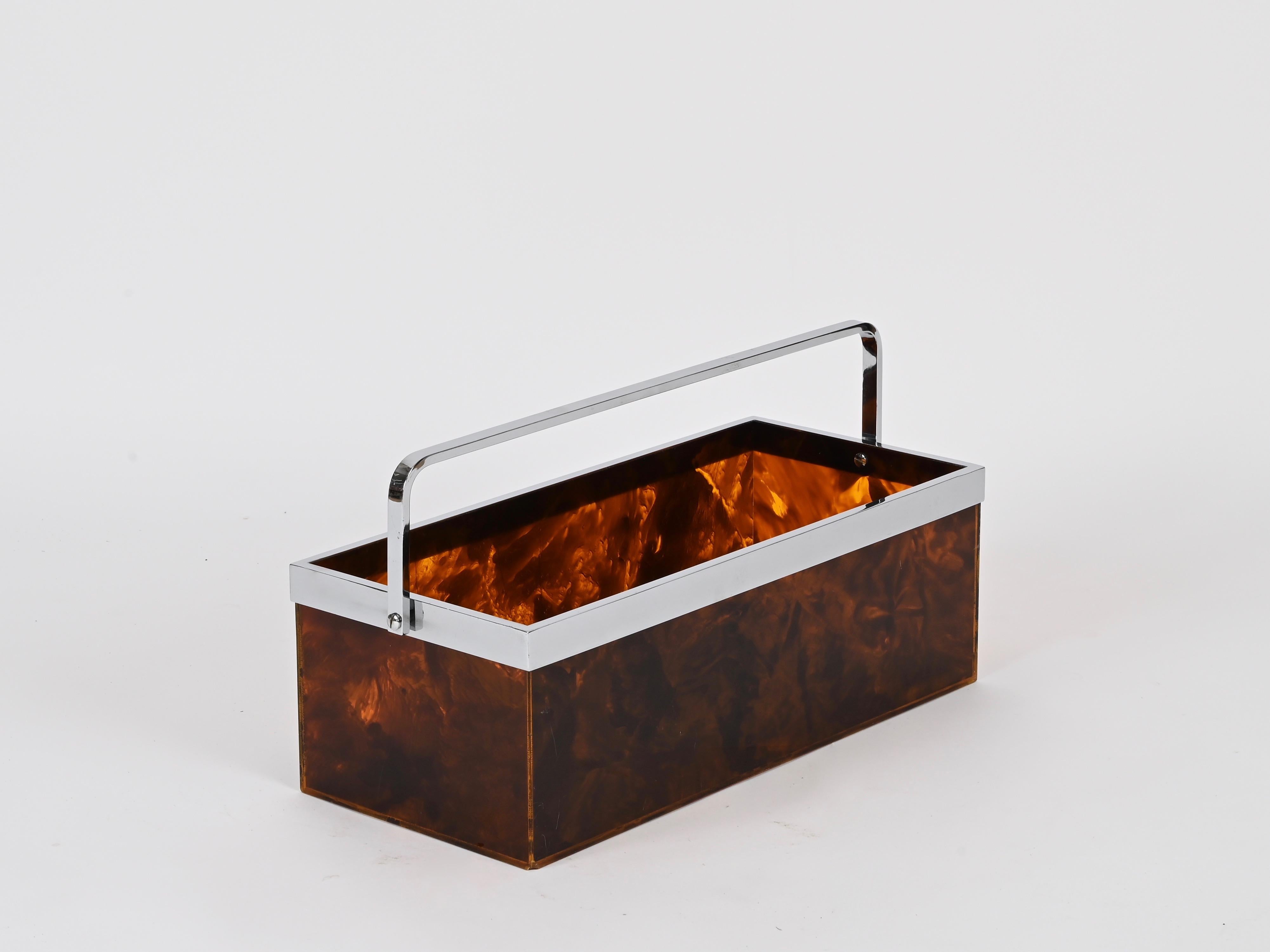 Marvelous large Mid-Century magazine rack made in a wonderful tortoiseshell effect lucite with a chrome-plated rim and handle. This incredibly elegant and unique piece was produced in Italy during the 1970s and its design is attributed to a Dior