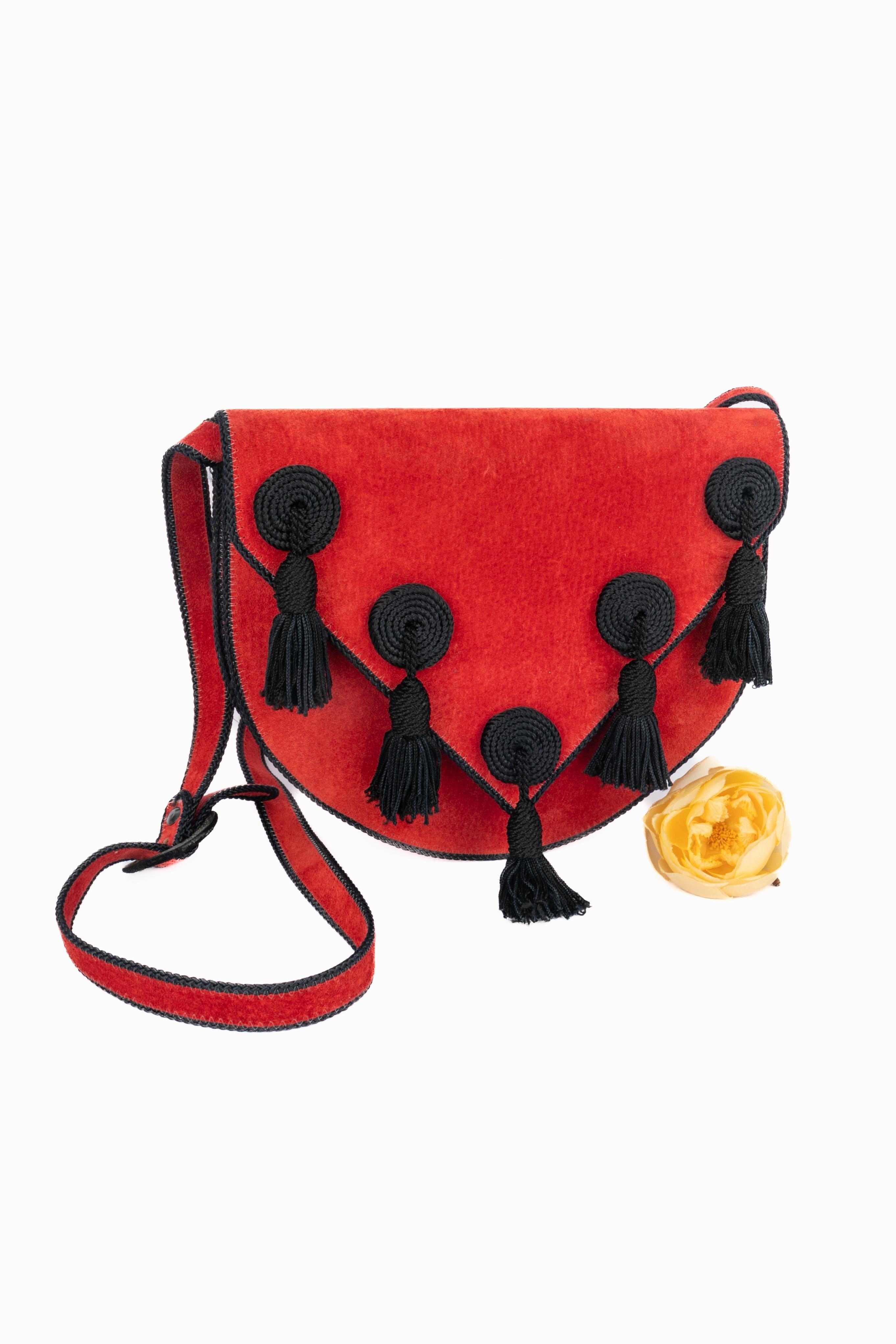 DIOR - (Fabricado en Francia) Bolso rojo de piel del revés con pompones de adorno. Pieza de los años 1975.

Estado:
Muy buen estado

Dimensiones:
Altura: 20 cm - Anchura: 24 cm - Profundidad: 2 cm - Asa: 102 cm

SKU:S163