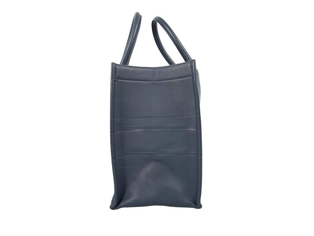 The Dior Book Tote is loved for its spacious construct and simple yet fun appeal. This Medium sized Book Tote is made from denim blue coloured leather, featuring the notable, signature details to the front. It comes with two top handles and a roomy