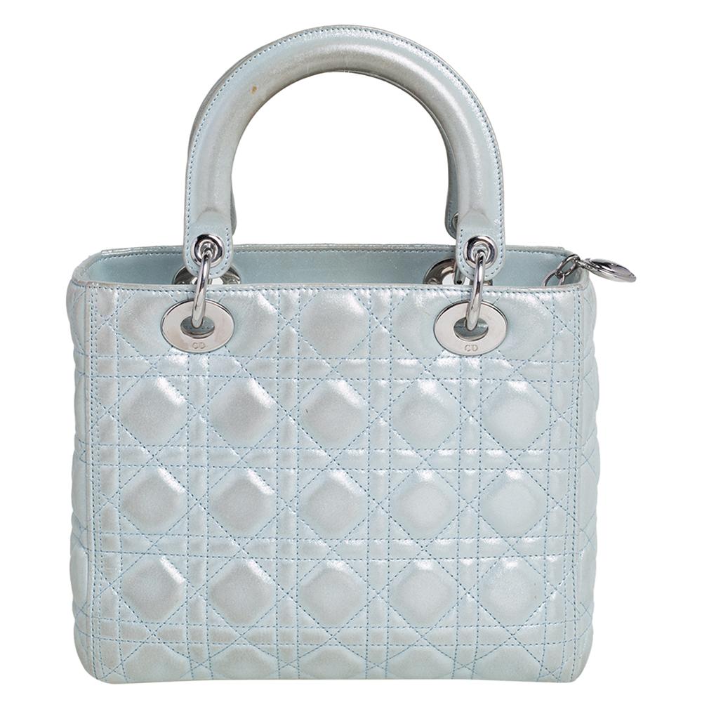 Die Lady Dior Tote ist eine Kreation von Dior, die weltweit Anerkennung gefunden hat und heute eine begehrte Tasche ist, die jede Fashionista unbedingt haben möchte. Diese hellblaue Tote wurde aus schimmerndem Leder gefertigt und trägt das