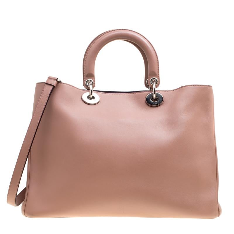 The Diorissimo bag from Dior is a timeless piece. The leather bag comes in a luxurious brown hue with silver-tone hardware and Dior letter charms. It features double top handles, a detachable shoulder strap and protective feet at the bottom. A snap