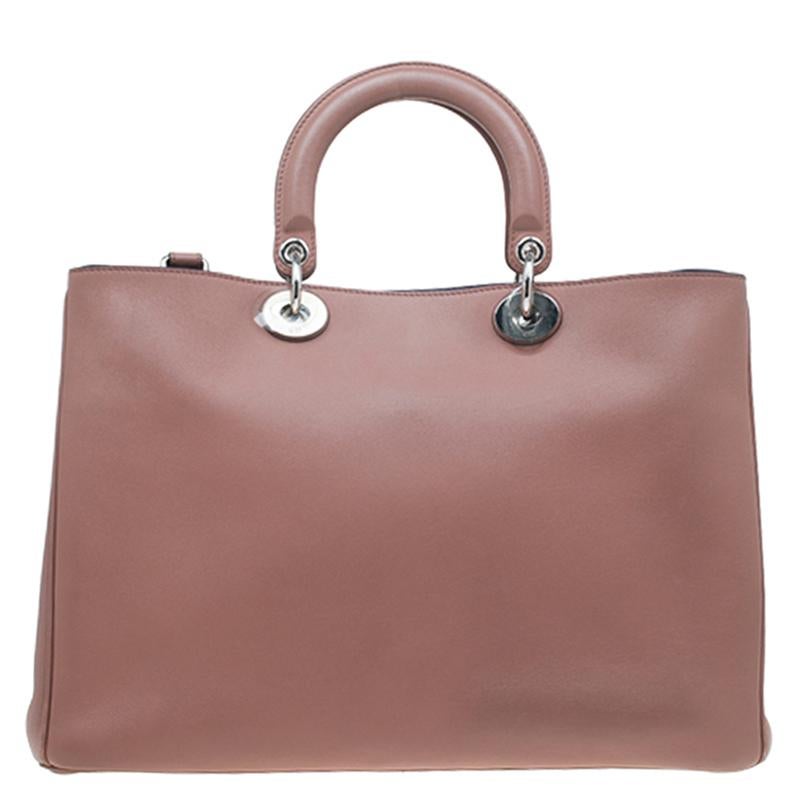 This large Diorissimo shopper tote is a classic Dior creation and is super chic yet practical. It features a smooth gorgeous light brown leather exterior with two leather top handles and a detachable shoulder strap. It comes accented with