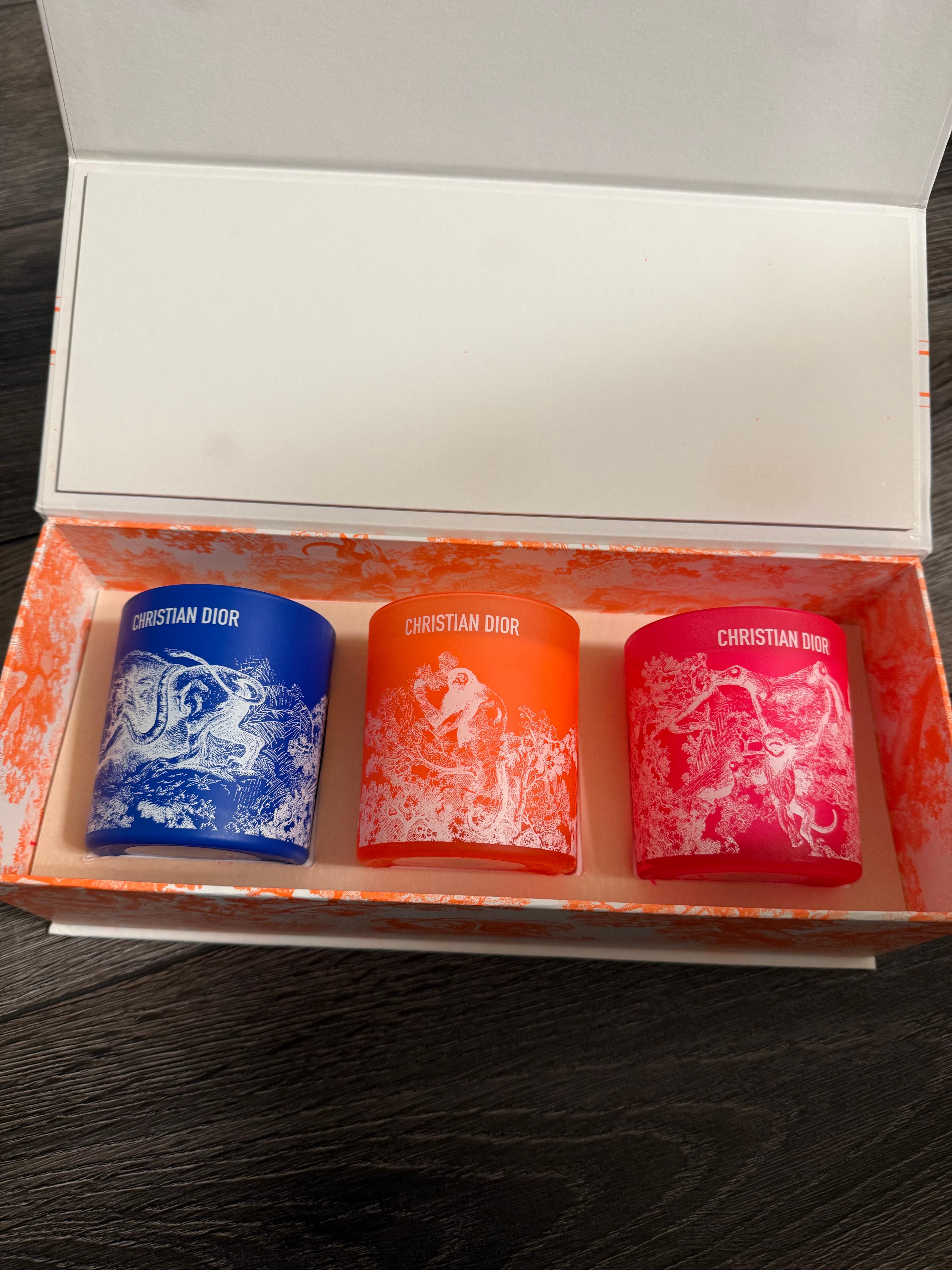 Dior Riviera brand new in box set of three perfumed candles. 
Dioriviera summer capsule designed by Maria Grazia Chiuri.
Etched glass containers in blue, coral and orange. 
Box size measurement approx. 11