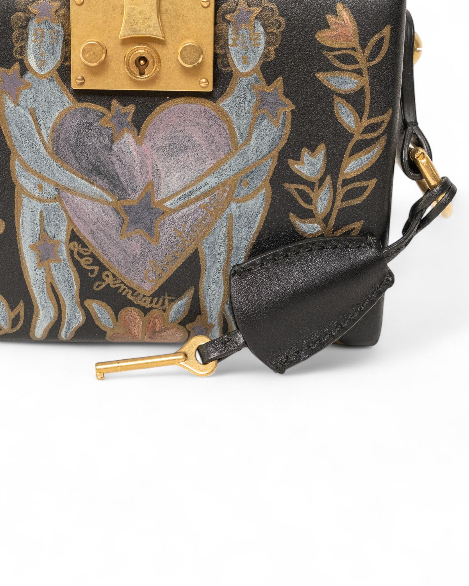 

Borsa Dior, modello LockBox, realizzata in pelle nera liscia con un affascinante dipinto frontale che raffigura il simbolo dei gemelli, arricchita da hardware dorato. Questa borsa è munita di una tracolla in pelle nera rimovibile, offrendo