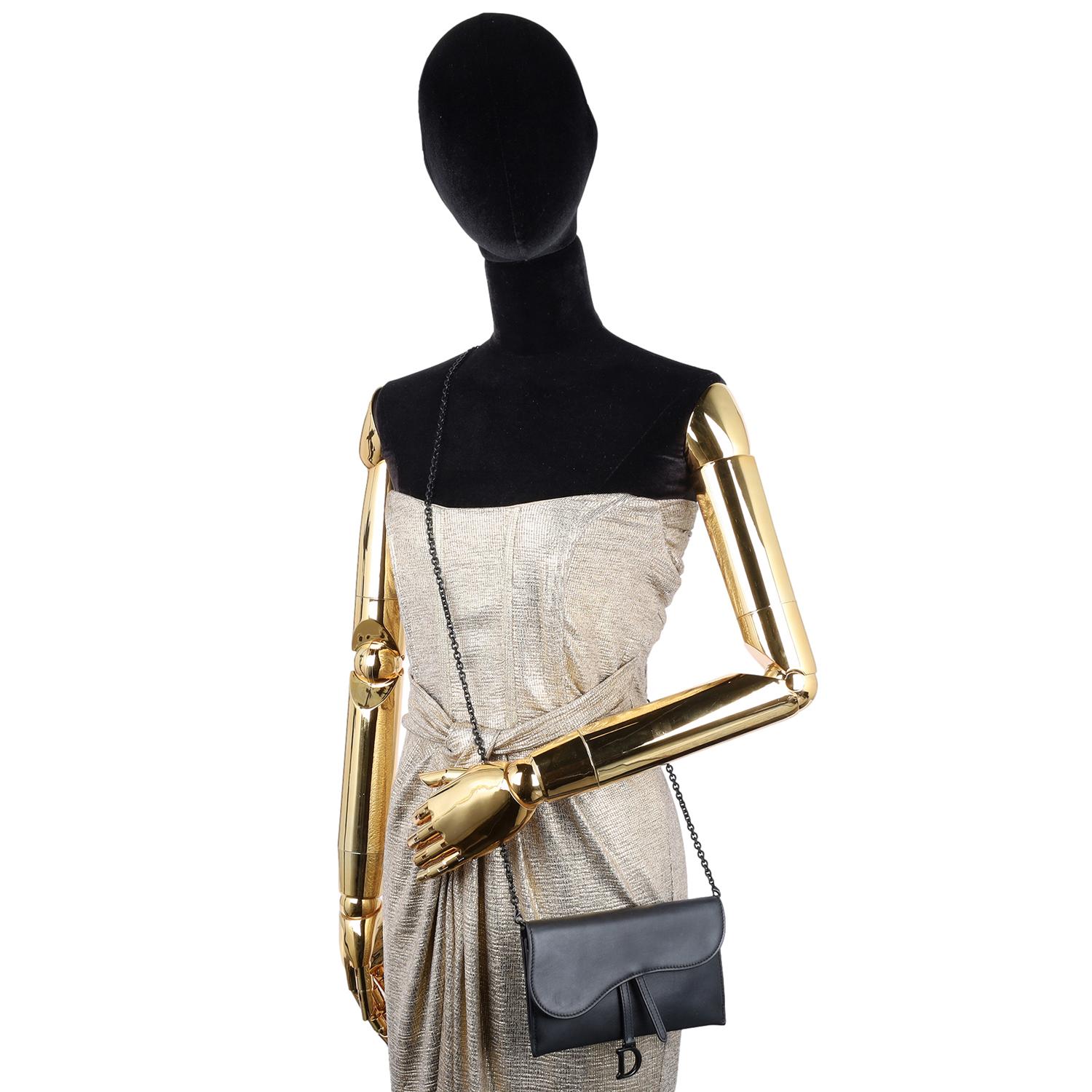 Authentic, pre-owned Christian Dior Long Saddle Wallet with Chain. Features black ultramatte calfskin, front flap with matte metal D stirrup clasp, snap closure, removable black strap. The interior has 6 cc slots, 3 patch pockets.

Use this bag as a