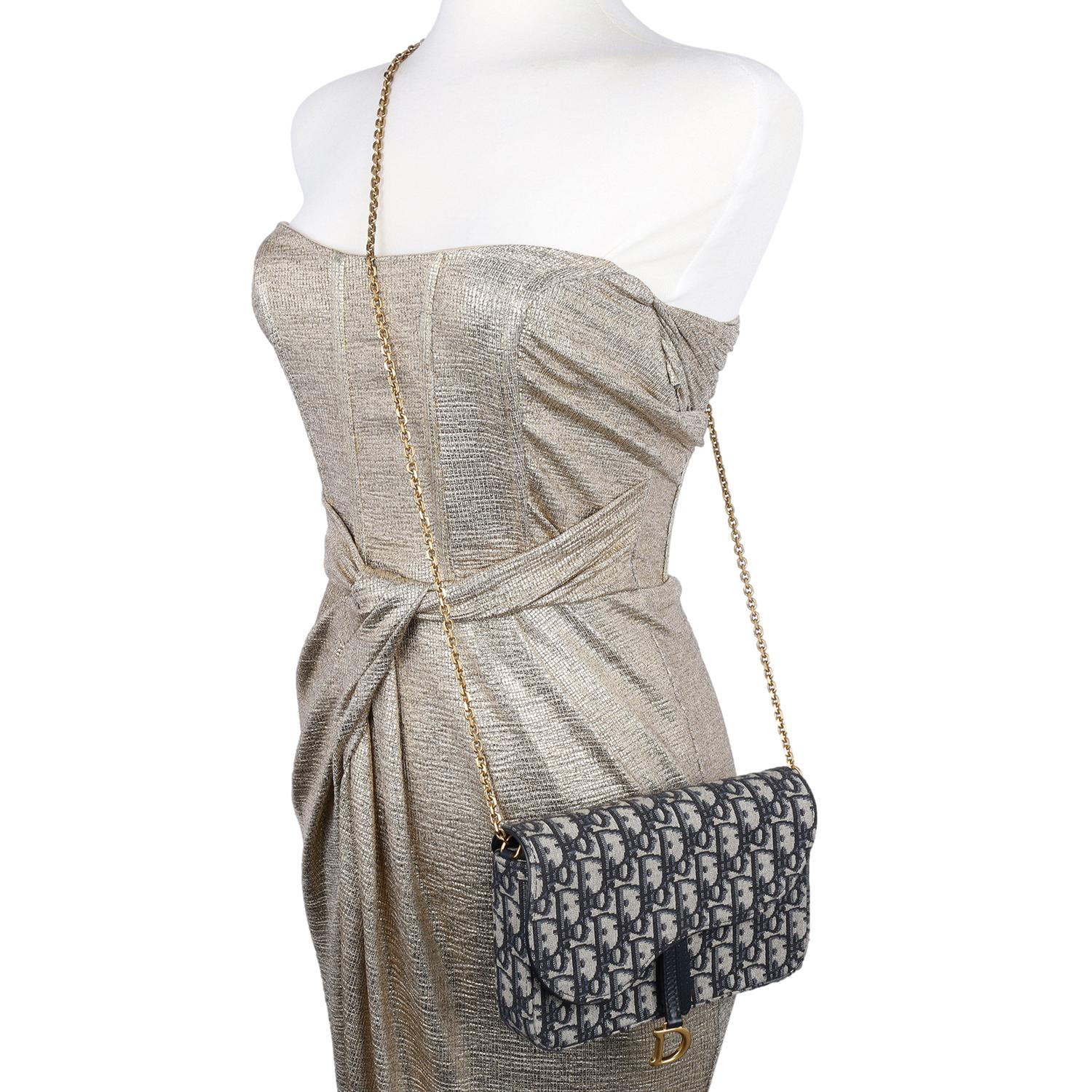 Authentic, pre-owned Dior Blue long Saddle wallet on a chain. The long Saddle wallet features blue Dior Oblique jacquard, combines modern elegance with a sleek, streamlined design. This sophisticated piece is adorned with an asymmetric flap snap