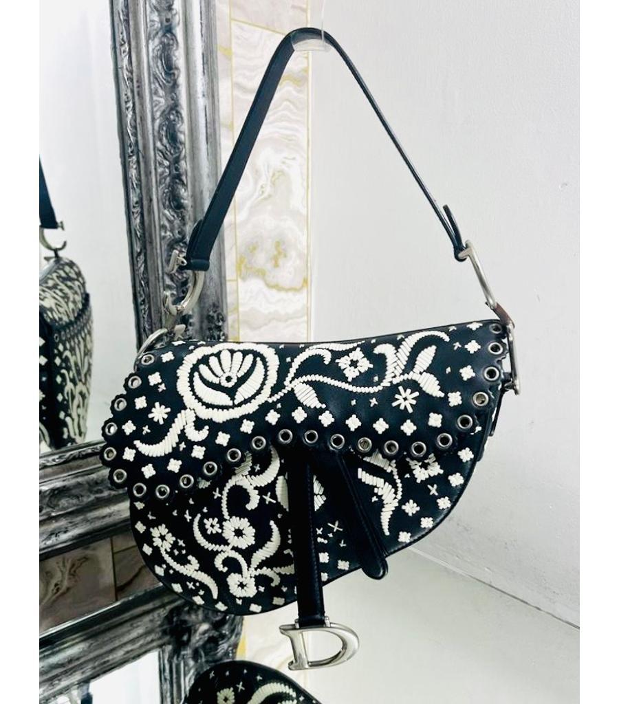 Dior Ltd Edition Leather Embroidered Saddle Bag

Black shoulder bag designed with white leather Paisley embroidery.

Featuring silver eyelet trimmed front flap detailed with 'D' stirrup clasp with magnetic strap.

Styled with 'CD' signature on