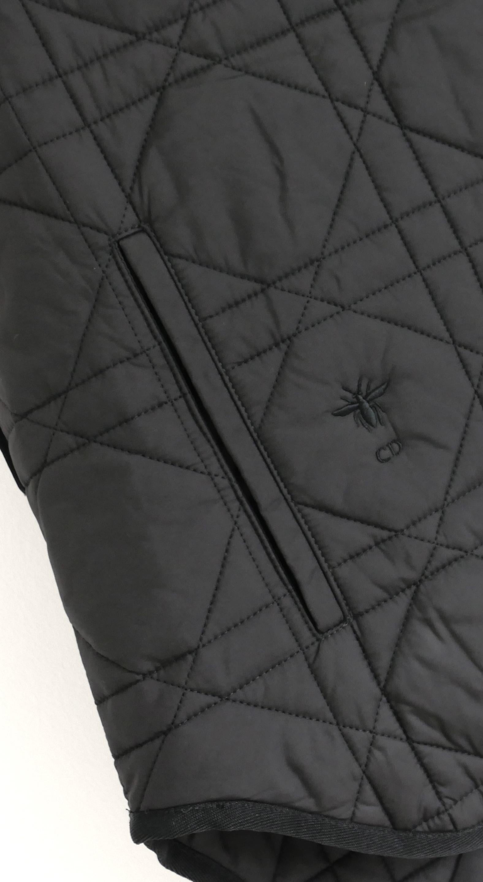 Genial chaleco acolchado Dior Macrocannage. Sin usar. Fabricada en poliéster negro liso con el logotipo de la abeja bordado y ribetes de sarga. Tiene un corte supergrande con dobladillo trasero caído, ojales de imitación en el cuello, trabillas para