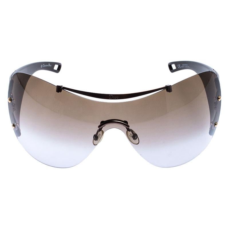 Block out the sun and keep your eyes protected wearing these stunning Dior shield sunglasses. Constructed from acetate and metal, the frame and arms have metallic hues. This pair features brown lenses and logo detailing along the temples to complete