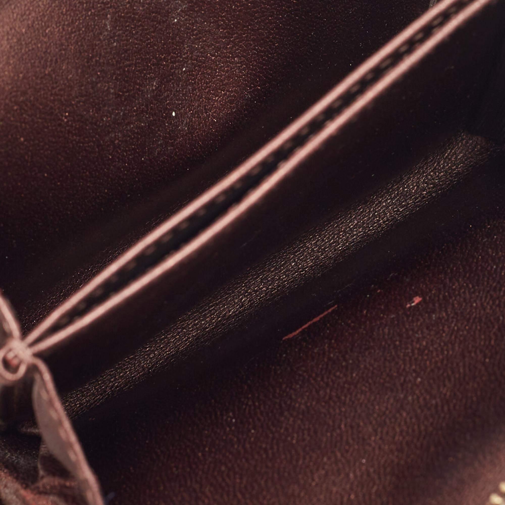 This Dior wallet is conveniently designed for everyday use. Crafted from Cannage detailed leather in a metallic burgundy shade the wallet has a zip closure . It opens to reveal multiple slots for you to neatly arrange your cash and cards.