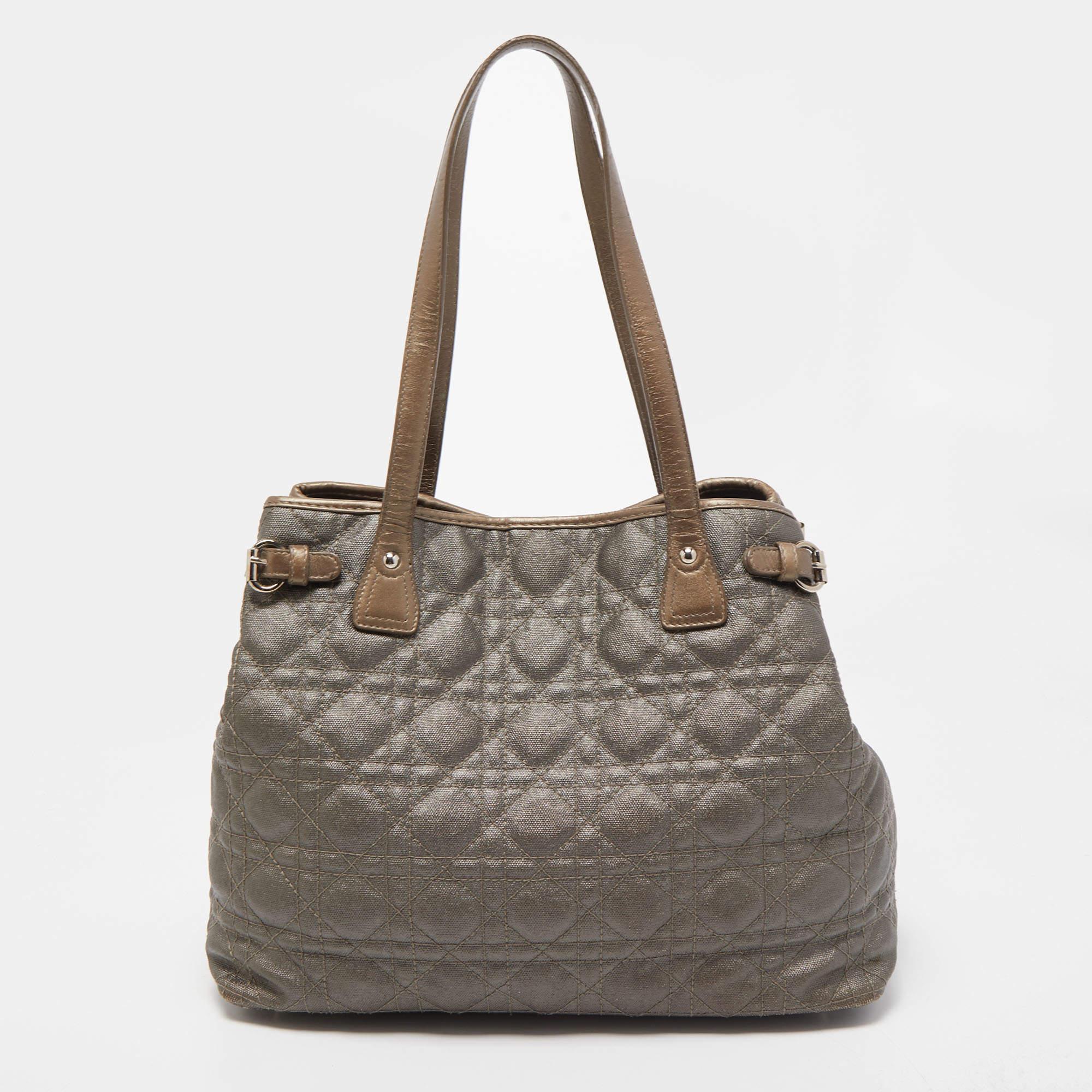 This tote from the Panarea collection by Dior is both urban and practical with its classic lines. Made from coated canvas in their signature Cannage quilt, this tote is accented with silver-tone hardware and DIOR charms. It also features dual
