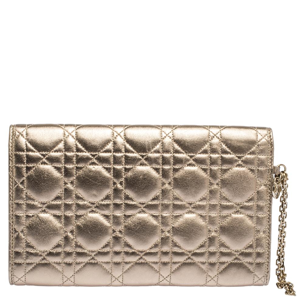 Diese metallisch-goldene Clutch wurde aus Leder gefertigt und trägt das charakteristische Cannage-Quilt. Sie ist mit einem Schloss mit Logogravur auf der vorderen Klappe ausgestattet:: das ein Innenfach aus Ledergewebe mit einem Steckfach sichert.