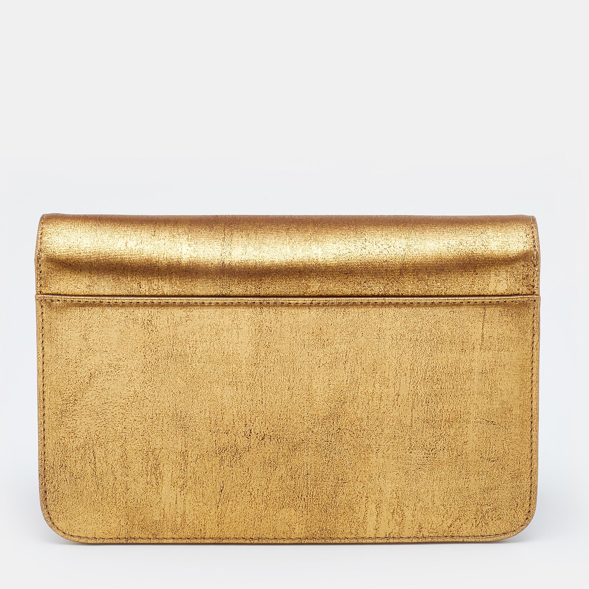 With a chic, structured design, this Dior shoulder bag is sure to earn you admiring glances. It is made from crinkled leather and has a striking metallic gold shade with gold-tone details. It is finished with a slender shoulder strap and a