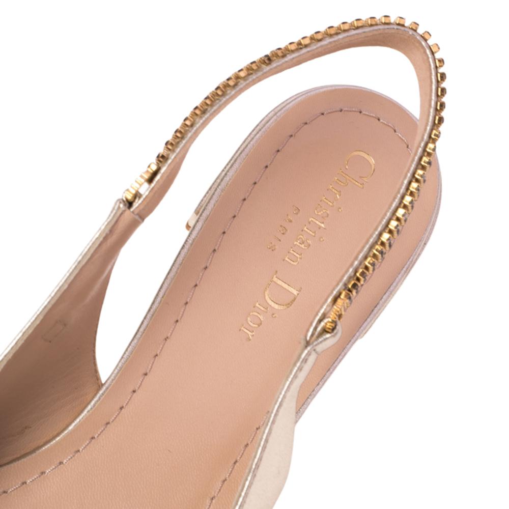 These popular ballerina flats exude an elegant and sophisticated aesthetic. Crafted from gold foil leather in a metallic gold shade, the sandals have a sleek design with pointed toes. Adorned with slingbacks featuring embellishments, these