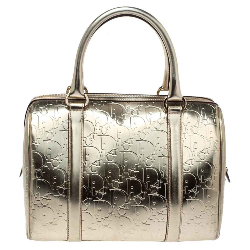 This Boston bag by Dior sweetly embodies luxe elegance! Crafted from Oblique monogram patent leather, this pretty bag features a top zip closure that opens to a canvas interior housing the brand label and pockets. It is completed with twin handles