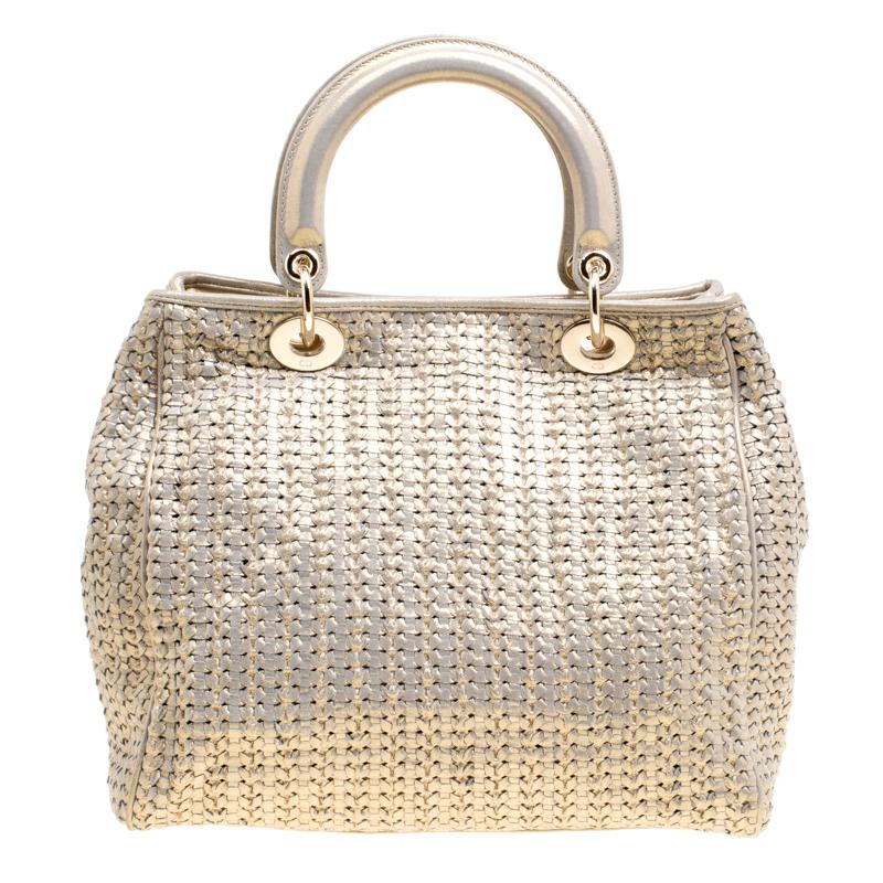 This sophisticated and feminine Lady Dior tote in your hand is apt for the perfect Dior look. Crafted from leather, this metallic gold tote is accented with a woven pattern and gold-tone hardware. It features signature Dior charms, two round handles