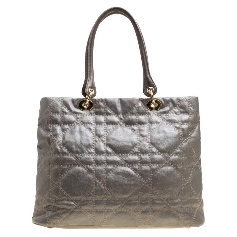 This sophisticated and feminine Lady Dior tote in your hand is apt for the perfect Dior look. Crafted from coated canvas, this metallic grey tote is accented with cannage pattern and gold-tone hardware. It features signature Dior charms, dual