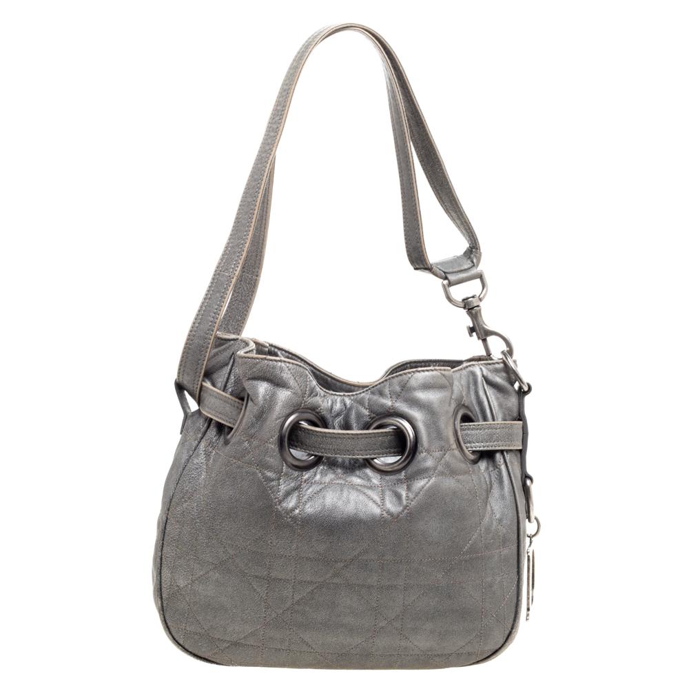 This metallic grey Dior bag will help you ace your regular casual look. It has been crafted from leather and styled in the brand's signature cannage pattern. It has a top drawstring closure and is equipped with a shoulder strap. The spacious