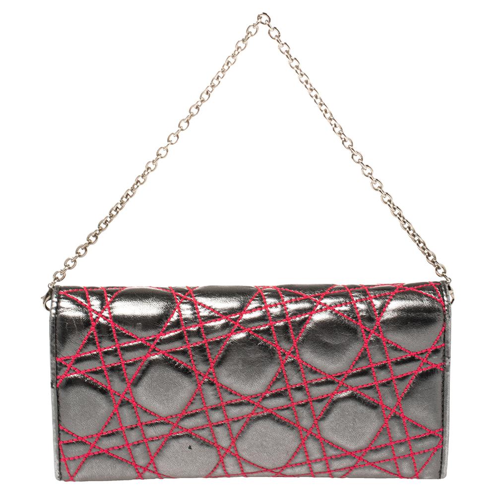 Displaying the signature Cannage in red on a metallic grey leather base, this chain wallet is unmistakably Dior. The wallet has a flap design, a chain handle, and an interior with multiple card slots and a zip pocket.

