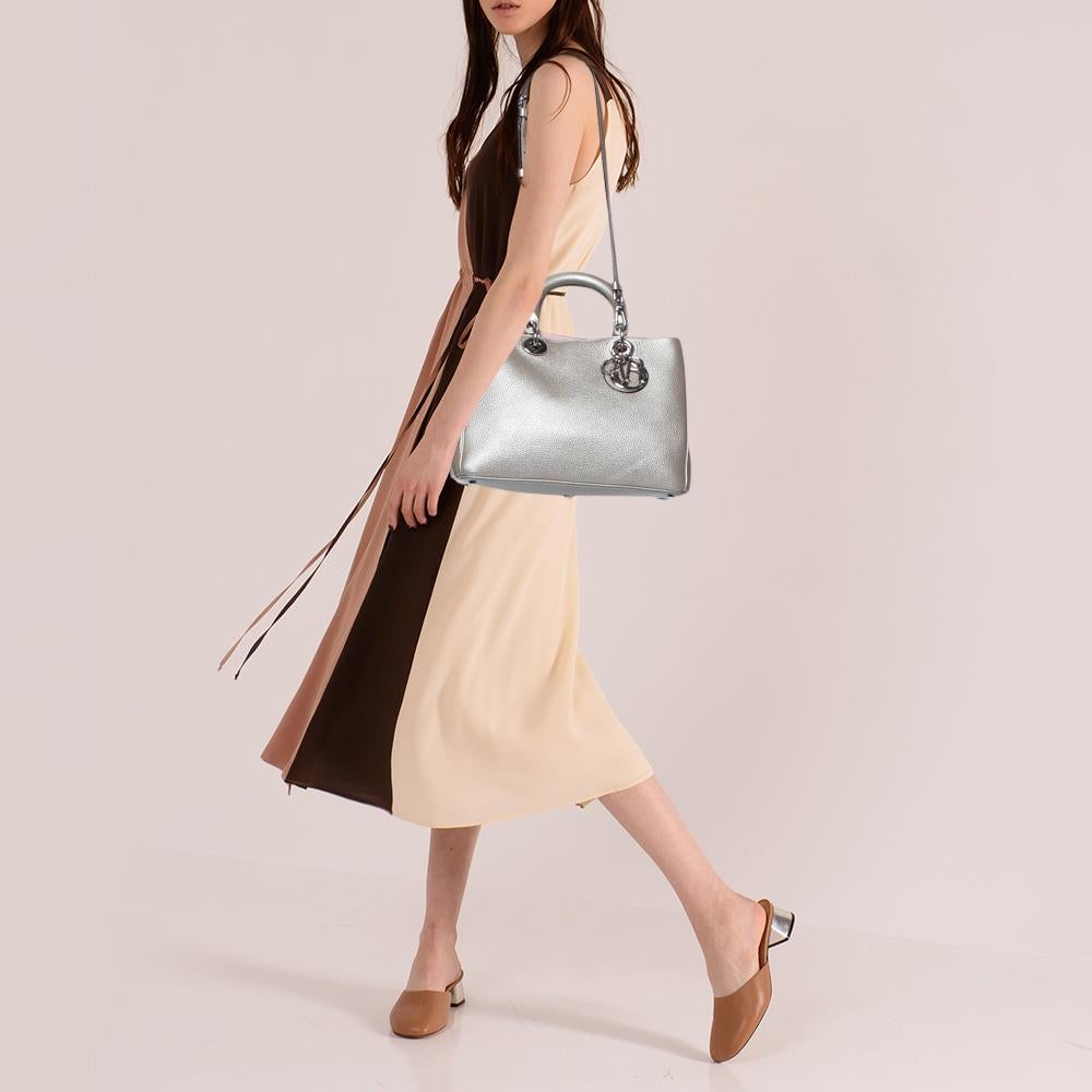 The Diorissimo shopper tote from Dior is a piece that has never gone out of style. The leather bag comes in a pleasing shade with silver-tone hardware and Dior letter charms. It features double top handles, a small pouch, and protective feet at the